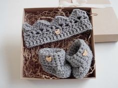 two crocheted baby booties in a gift box with ribbon and bow tie