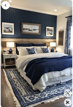 a bedroom with blue and white decor on the walls, bedding and rugs