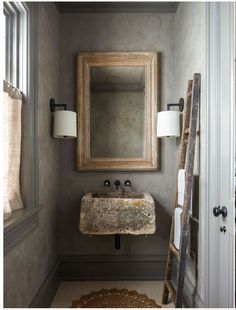 a bathroom with a mirror, sink and ladder