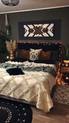 a bedroom decorated in black, white and gold with plants on the wall above the bed