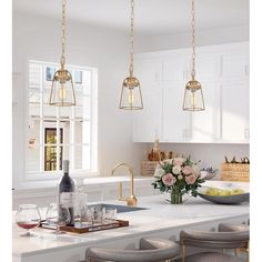 a kitchen with white cabinets and marble counter tops, two pendant lights hanging over the island