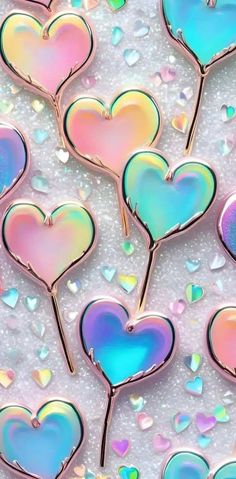 several heart shaped pins sitting on top of a white surface with iridescents