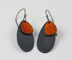 two pairs of earrings with orange and black accents