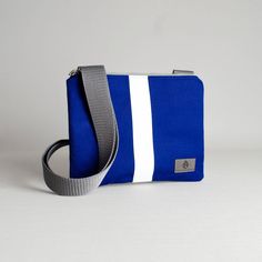 Our crossbody pouch now comes in a stunning blue and white pattern! With a slim profile that expands to hold your keys, phone, card holder and more, this pouch is classic and functional. Upcycled like all of our bags, this crossbody pouch was handcrafted by a woman in recovery and was uniquely designed from a pair of pants worn by the West Point Concert/Marching Band and the Hellcats field music group. Purchase this upcycled, crossbody pouch and create possibilities for women on our team to sust Blue Shoulder Phone Bag For On-the-go, Blue Phone Bag With Cell Phone Pocket For On-the-go, Blue Rectangular Phone Bag With Removable Pouch, Blue Shoulder Bag With Zipper Pouch As Gift, Blue Travel Pouch Phone Bag, Blue Travel Phone Pouch Bag, Functional Blue Phone Bag With Cell Phone Pocket, Everyday Blue Shoulder Bag With Cell Phone Pocket, Blue Rectangular Phone Bag As Gift