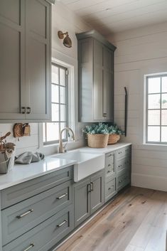 a kitchen with gray cabinets and white counter tops