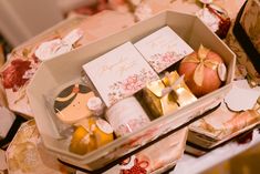 a box filled with lots of different items on top of a table covered in wrapping paper