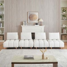 a living room with white furniture and a fireplace