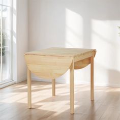 a wooden table sitting on top of a hard wood floor next to a white wall