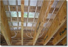 the inside of an unfinished house with electrical wires running through it and wood framing on the ceiling