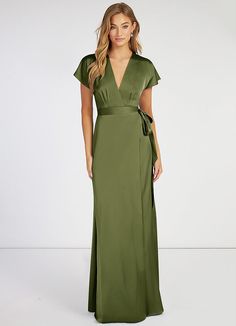 a woman in a long green dress with a bow on the waist and short sleeves