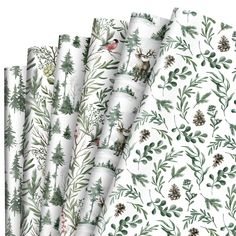 four white wrappings with green leaves and pine cones on them, all printed in different colors