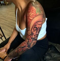 a woman with a buddha tattoo on her arm