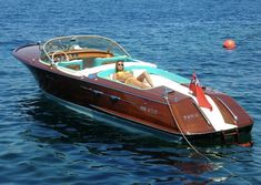 a woman sitting on the back of a boat in the water