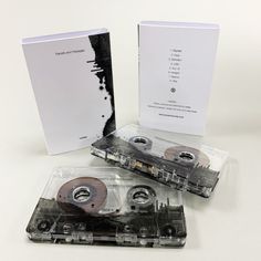 two cassettes are sitting in their packaging on a white surface, one is empty and the other has been opened