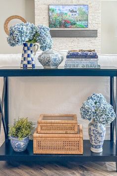 blue and white vases are sitting on a shelf in front of a fireplace with books