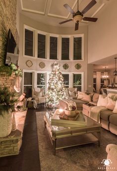 a living room filled with furniture and a christmas tree in the middle of the room