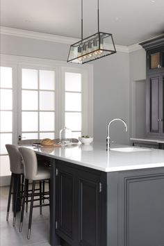 a large kitchen with an island, sink and bar stools in it's center