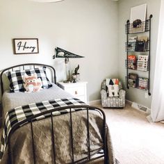 a bed room with a neatly made bed next to a book shelf and shelves on the wall