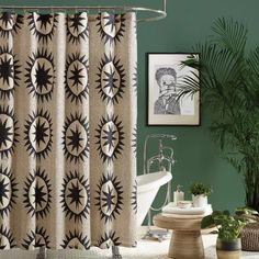 a bathroom with green walls and a shower curtain in the center, surrounded by potted plants