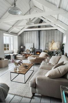 a living room filled with furniture and a fire place in the middle of the room