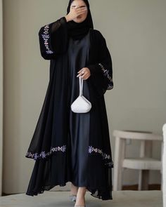 *NEW 2024 SEASON* This classy layered chiffon abaya features hand made flowery embroidery at the first layer and at the sleeves, and of course Our Signature soft and buttery Lazer (ليزر) Chiffon Hijabs. The abaya has no buttons and it comes with a luxurious long sleeved grey slip dress. The sizes refer to the length of the abaya (in inches) from shoulder down.  The model is 1.52 m and wears size 52. Abaya Material:  Chiffon Scarf Material: 100% High Quality Laser (ليزر) Chiffon Care instructions: Dry cleaning only. Grey Slip Dress, Scarf Material, Chiffon Scarf, Abayas Fashion, Two Piece Sets, Care Instructions, Slip Dress, Hand Made, Two Piece