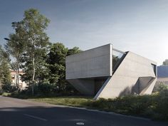 an architecturally designed concrete building on the corner of a street with trees in the background