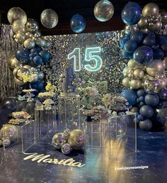 a room filled with lots of balloons and confetti on top of tables in front of a number 15 sign