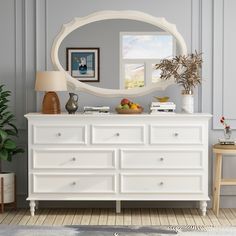 a white dresser and mirror in a room