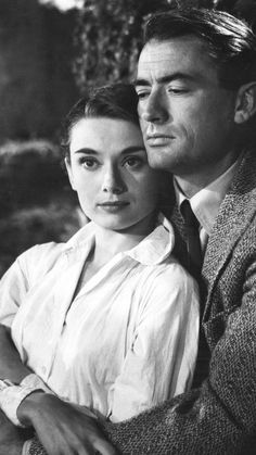 black and white photograph of a man hugging a woman's neck with her arm around him