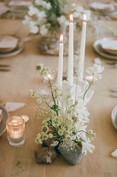 the table is set with white flowers and candles