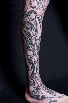 a man's leg with tattoos on it