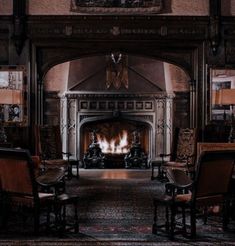 a living room with chairs and a fire place in the middle of it's fireplace