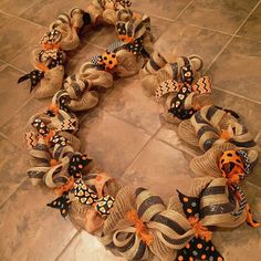 a wreath made out of burlocks with orange and black polka dots on it