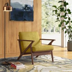 a yellow chair sitting on top of a rug next to a wooden wall mounted lamp