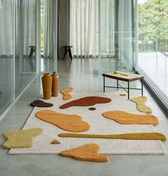 an area rug with various shapes and sizes on the floor in front of a large window