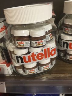 nutella jars are stacked on the shelf in a grocery store, with one jar labeled nutella