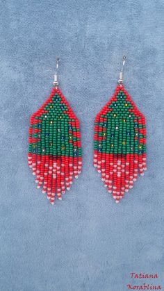 red, green and white beaded earrings on blue background