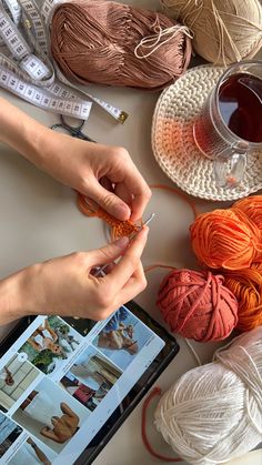 two hands are knitting yarn on an ipad