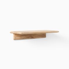 a wooden shelf against a white wall with no one on it's legs or feet