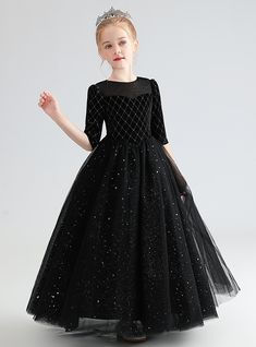 Holding onto the essence of timeless elegance and modern sophistication, this black flower girl dress is a perfect choice for any formal occasion. The dress features a fitted bodice adorned with a delicate diamond pattern, adding a touch of luxury and refinement. The three-quarter-length sleeves provide a vintage feel, while the sheer neckline introduces a contemporary element to the design. The waist is gathered, enhancing the silhouette and leading to a full tulle skirt that cascades to the fl Black Flower Girl Dress, Black Sequin Shorts, Black Velvet Shorts, Celebration Design, Black Ball Gown, Nye Wedding, Full Tulle Skirt, Wedding Dresses Beaded, Wedding 2024