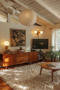 a living room filled with furniture and a flat screen tv on top of a wooden table