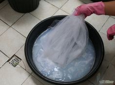 a person in pink gloves is cleaning a bucket with water