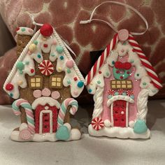 two gingerbread houses are decorated with candy canes