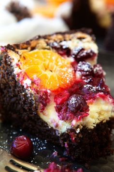 a piece of cake on a plate with orange slices and cranberry toppings