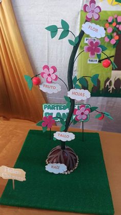 a table with a tree made out of paper and cut outs on it, sitting on top of a green mat