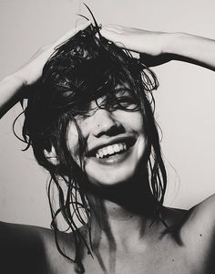 a black and white photo of a woman with wet hair