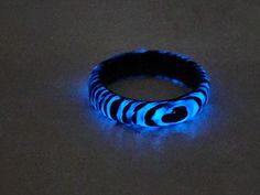 a black and white ring with blue lights on it's side sitting on a table