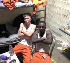 two men are sitting in bunk beds with their arms crossed and looking at the camera