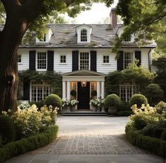 a large white house surrounded by trees and bushes