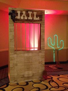 a door with neon lights and a cactus on the floor in front of it that says jail